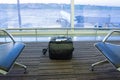 Suitcase in airport departure lounge, airplane in background, summer vacation concept Royalty Free Stock Photo