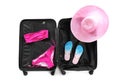 Suitcase with bikini, hat and slippers on white background Royalty Free Stock Photo