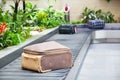suitcase on a conveyor belt surrounded by green tropical plants in a baggage claim area at the airport travel background Royalty Free Stock Photo