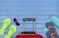 Suitcase with flip-flops, beach towel and sunglasses on wooden table. Royalty Free Stock Photo