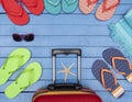 Suitcase with flip-flops, beach towel and sunglasses on wooden table. Royalty Free Stock Photo