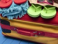 Suitcase with flip-flops, hat and sunglasses on wooden table. Royalty Free Stock Photo