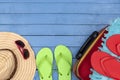 Suitcase with flip-flops, hat and sunglasses on wooden table. Royalty Free Stock Photo