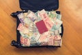 Suitcase full money of south-east Asia with passport and American hundred dollar bill. Royalty Free Stock Photo