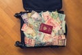 Suitcase full money of south-east Asia with russian passport and American hundred dollar bill. Royalty Free Stock Photo