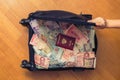 Suitcase full money of south-east Asia with russian passport and American hundred dollar bill. Royalty Free Stock Photo