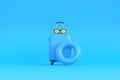 Suitcase, glasses and inflatable circle on a blue background with copy space Royalty Free Stock Photo
