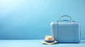 Suitcase and hat against a blue background. Travel concept. minimal style