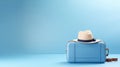 Suitcase and hat against a blue background. Travel concept. minimal style