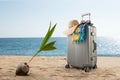 Suitcase with hat, pareo and sunglasses on sunny tropic beach