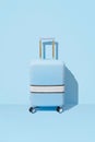 Suitcase on a pastel blue background with long deep shadows. Minimal style