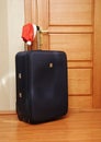 Suitcase and santa hat against a wooden door. Royalty Free Stock Photo