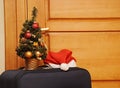 Suitcase and santa hat against a wooden door. Royalty Free Stock Photo