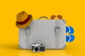 Suitcase of a traveler with straw hat and retro film photo camera on yellow background Royalty Free Stock Photo