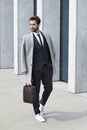 Suited businessman with coat and case