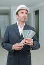 Suited man in apartment holding colour samples