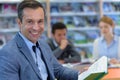 suited man holding book in library Royalty Free Stock Photo