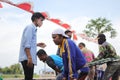 A group of Indonesians tied using sarongs pull each other in a traditional game called Tarik Sarong or Tarik sarung during Royalty Free Stock Photo