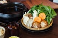Sukiyaki vegetables set including cabbage, false pak choi, carrot, shiitake, enokitake and tofu in bamboo basket