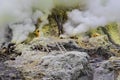 Sulfur mining operation, Mount Ijen volcano crater, Indonesia.Volcanic gas rising from ground. Yellow sulfur scattered on ground