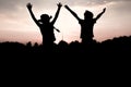 Sulhouettes of children jumping off a hill at sunset Royalty Free Stock Photo