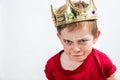 Sulking funny face of a little boy wearing a crown Royalty Free Stock Photo