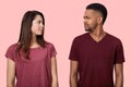 Sullen displeased multiethnic lady and male looks with discontent at each other, frown faces, dont like something, wear t shirt,