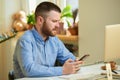 Sullen man with a beard searching the internet for news on a smartphone at home Royalty Free Stock Photo