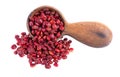 Sumac seeds in wooden spoon, isolated on white background. Whole dry Rhus berry.