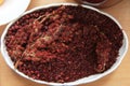 Dried sumac seasoning in a wooden bowl, top view. a handful of red sumac powder in a plate abstract background . Sumak grains and