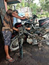 SUMATRA UTARA, INDONESIA - MAY 16 2020: Workers in vehicle service shops working on motorcycles. in the middle of the covid-19