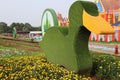 a duck-shaped monument in the middle of a flower garden at the Jatinangor National Flower Park tourist attraction