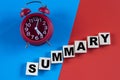 SUMMARY - word on wooden cubes on a multi-colored background with an alarm clock Royalty Free Stock Photo