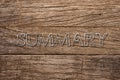 summary written over wooden background