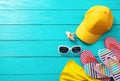 Summer accessories. Cap, sunglasses, flip flops, shell and oranges on blue wooden background. Top view and copy space Royalty Free Stock Photo