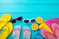 Summer accessories. Flip flops, sunglasses, towels and oranges on blue wooden background. Top view and copy space. Royalty Free Stock Photo