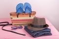 accessories - sunglasses, straw beach bag, sun hat, belt and flip flops on pink wooden table Royalty Free Stock Photo