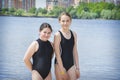 In the summer afternoon on the beach, two girls girlfriends play on the banks of the river Royalty Free Stock Photo