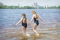 In the summer afternoon on the beach, two girls girlfriends play on the banks of the river Royalty Free Stock Photo