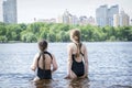 In the summer afternoon on the beach, two girls girlfriends play on the banks of the river Royalty Free Stock Photo