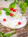 Summer alcohol fresh drink. Raspberry mint cocktail, slice of lime, ice cubes and raspberry on a natural wooden surface, Outdoor. Royalty Free Stock Photo