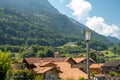 Summer alpine landscape. A small village surrounded by forest and mountains.