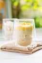 Summer appetizer of Thailand concept. Durian and sticky rice with coconut milk cream in transparent glass on white wooden table Royalty Free Stock Photo