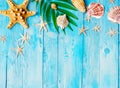 Summer background with beach sand, starfish coconut leaves, and shell decoration hanging on wooden background Royalty Free Stock Photo