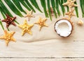 Summer background with beach sand, starfish coconut leaves, and shell decoration hanging on wooden background Royalty Free Stock Photo