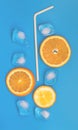Summer background composition with orange slices and ice cubes. Lemonade drink concept. Flat lay on a blue background Royalty Free Stock Photo