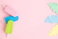 Summer background made of ice cream miniatures and colorful paper tropical leaves minimal creative concept