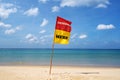 Summer background with red and yellow flag with text swim here on the sea beach Beautiful sea in Phuket Thailand Royalty Free Stock Photo