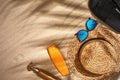 Summer background with straw hat, sunglasses, sunscreen bottle and flip flops