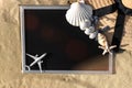 Summer background table. Globe, seashell, airplane and starfish near black desk on sea beach in sunny day. Copy space of summer Royalty Free Stock Photo